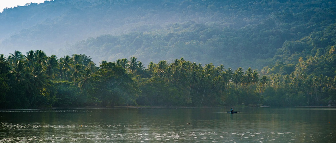 River with a forest in the background and a small boat on the water