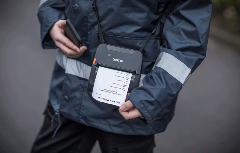 Uniformerad personal skriver ut rapport vid händelse